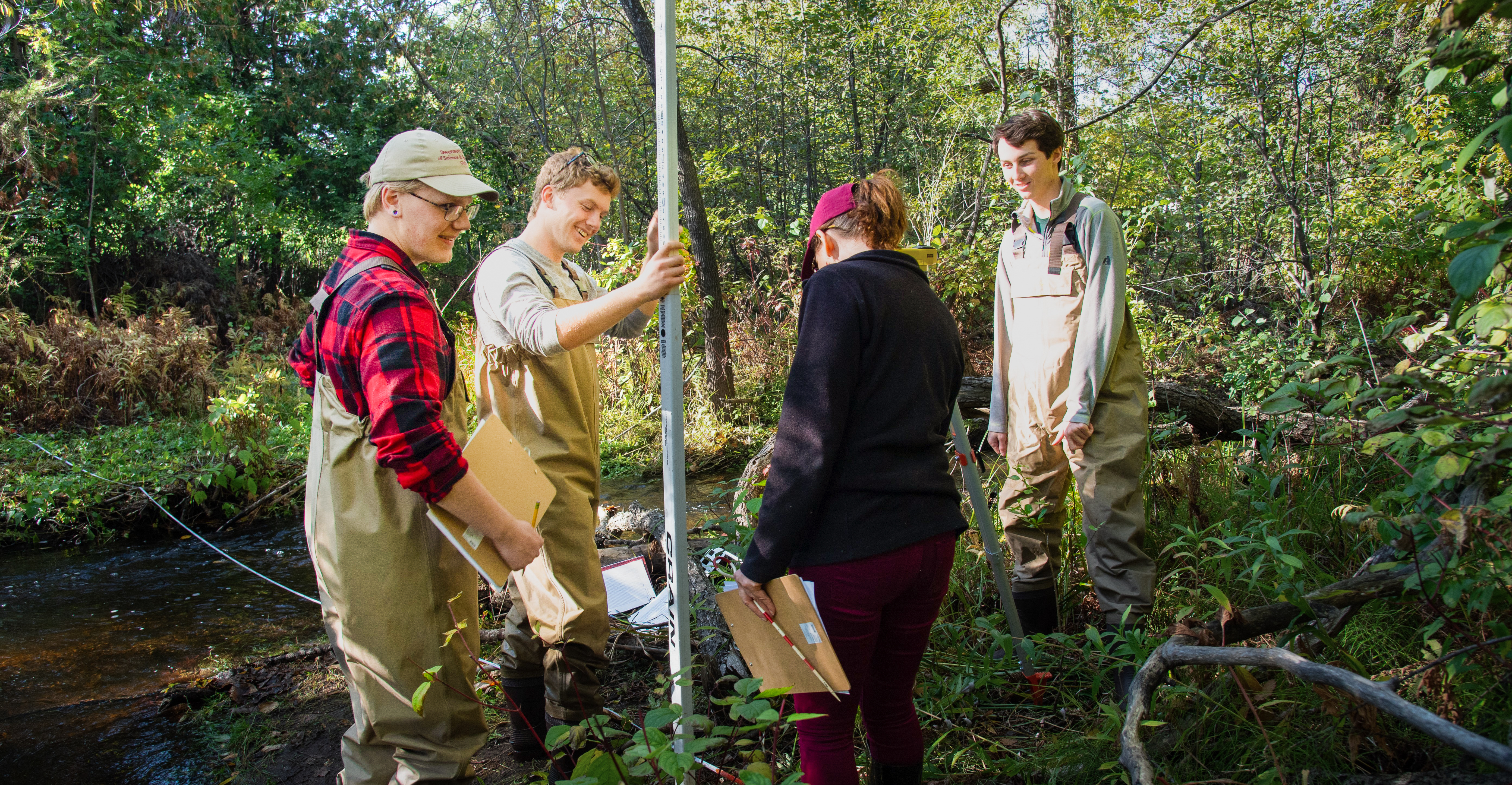 Four students conducting research at Tischer Creek