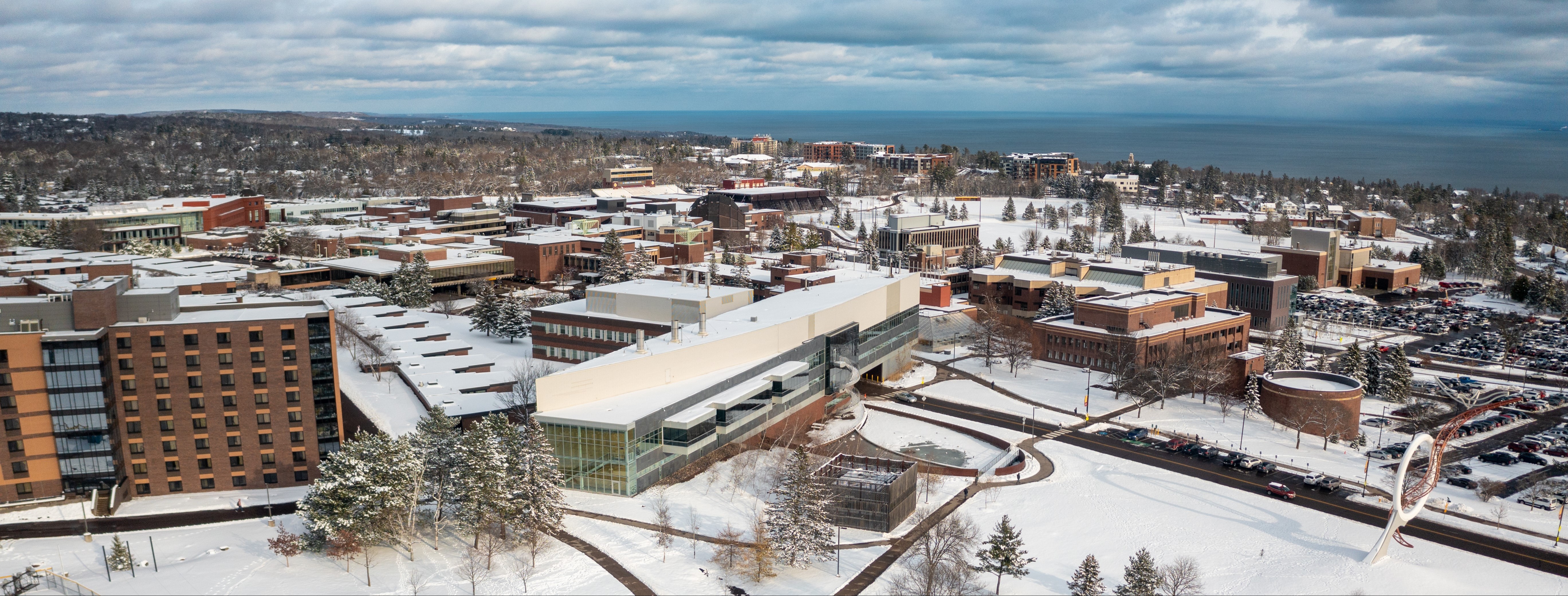 An aerial view of campus with fresh snow and Lake Superior in the distance