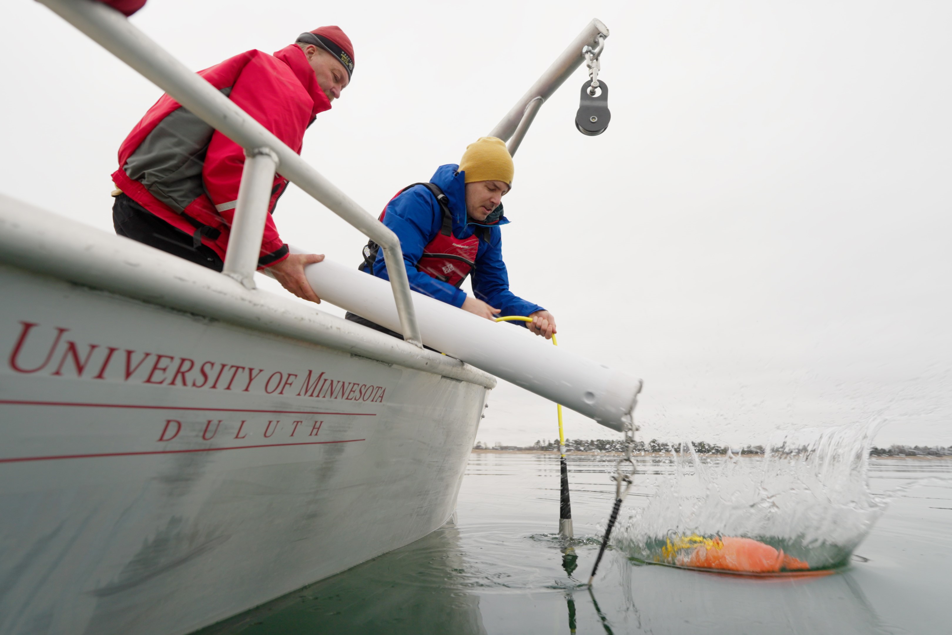 Jerry Henneck and Craig Hill deploy the buoy into Lake Superior from a small boat