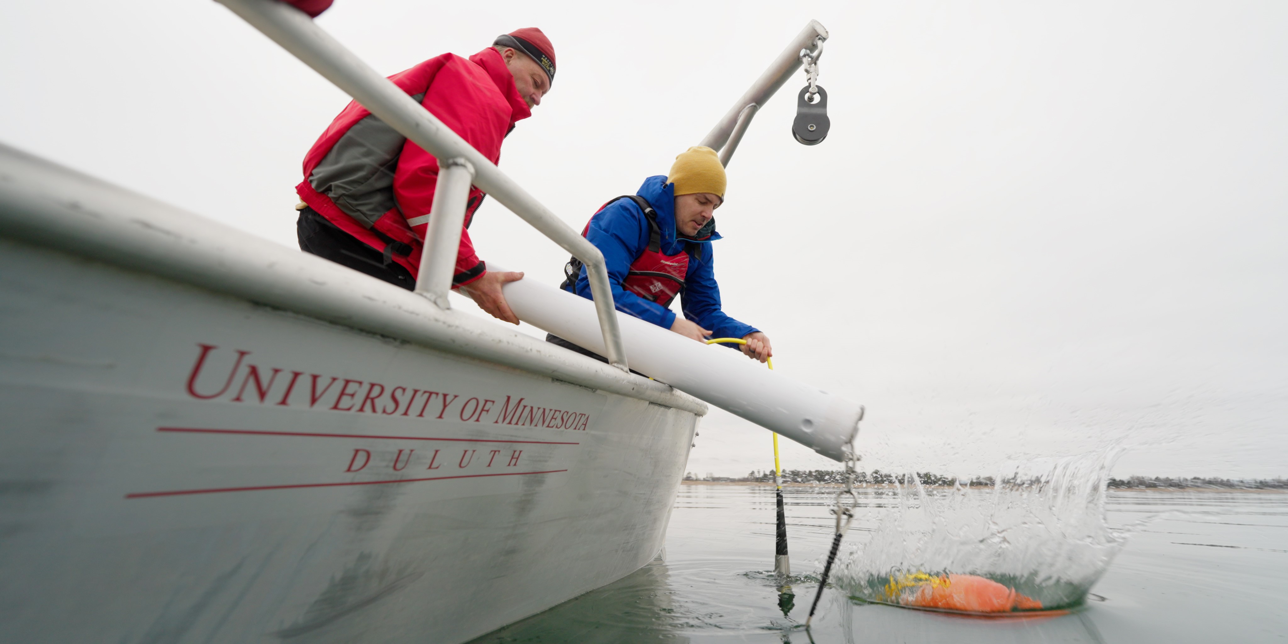 Jerry Henneck and Craig Hill deploy a buoy on Lake Superior from a small UMD boat